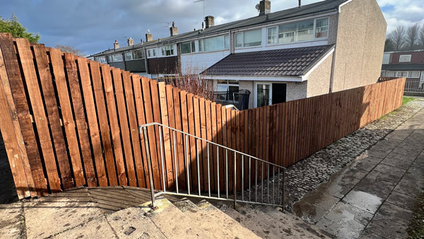 wooden fence lined along a pathway leading to a house showcasing modern outdoor design with two distinct sections of the fence